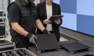 AV technician and facilities manager comparing spare LED modules beside an installed video wall